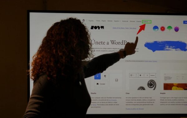 Speaker pointing at WordPress dashboard on screen during a presentation about the future of the platform and open-source collaboration.