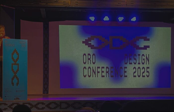 A female speaker delivers the opening remarks at the Oro Design Conference 2025 in Cagayan de Oro, with the event logo projected on stage.